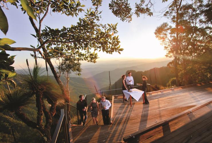 昆士兰州，奥莱利雨林度假村，会奖团队享受日落饮品并俯瞰长满热带雨林的山坡 © 奥莱利雨林度假村版权所有