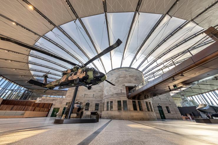 开阔玻璃穹顶下陈列着直升机、战斗机与坦克展品的 The Atrium © 澳大利亚战争纪念碑