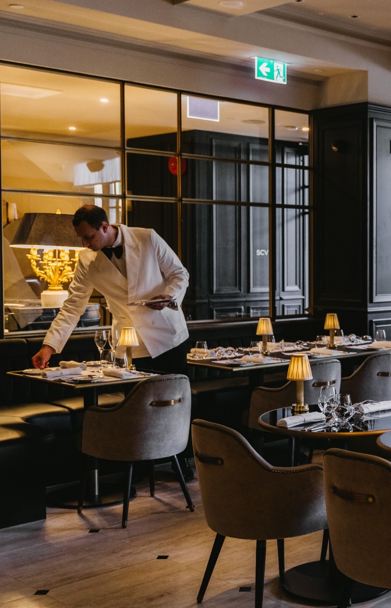 Maison Bâtard 餐厅的一名服务生在布置餐桌 © Liana Hardy 版权所有