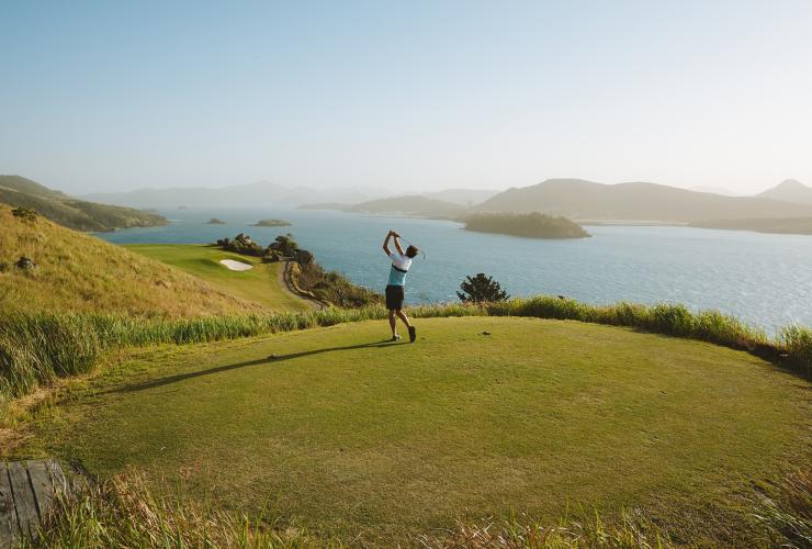 人们在丹特岛的汉密尔顿岛高尔夫球场打高尔夫球，背景是圣灵群岛 © 澳大利亚旅游局版权所有