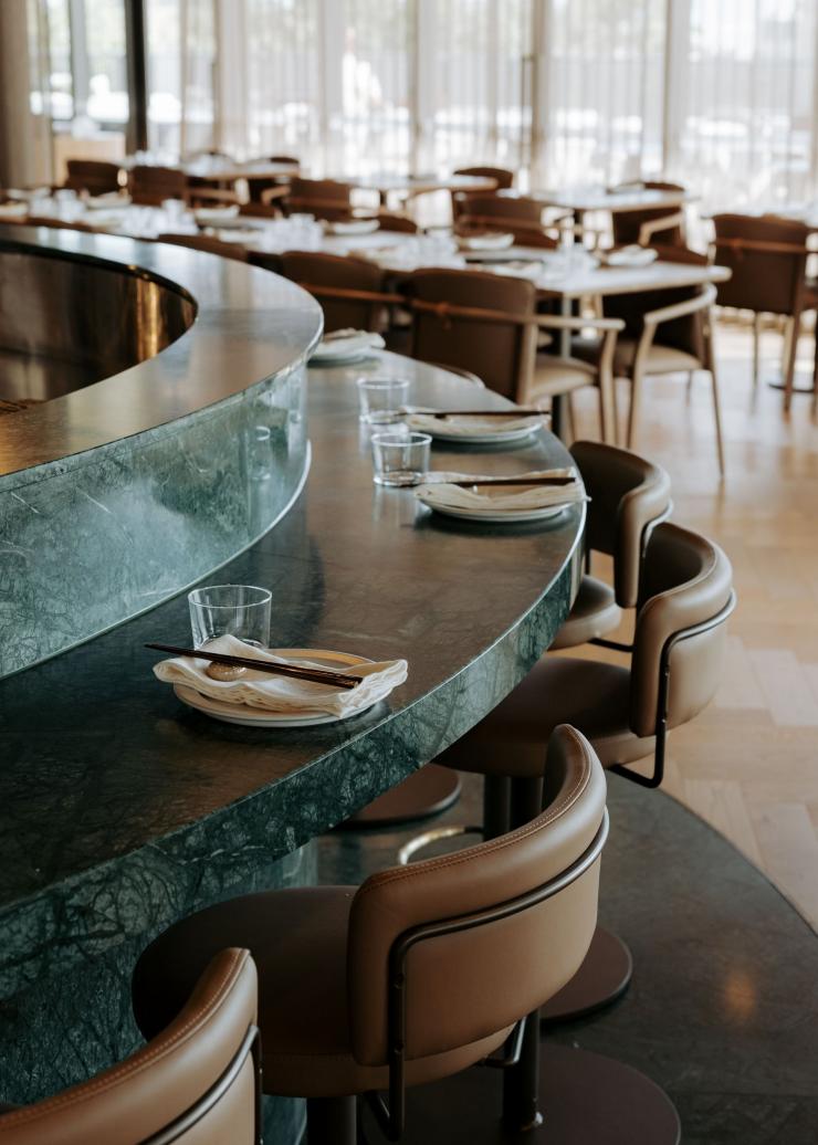 南澳大利亚州，阿德莱德，Yakisan 餐厅，绿色大理石吧台的弧形曲线与餐桌一景 © Yakisan 版权所有