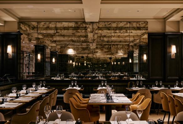 Maison Bâtard 的外观，一层为深色外观，其余部分为红砖外观。图片来源：Alex Drewniak 黑色立柱餐厅内，镜面瓷砖墙面倒映出餐桌和椅子 © Pete Dillon 版权所有