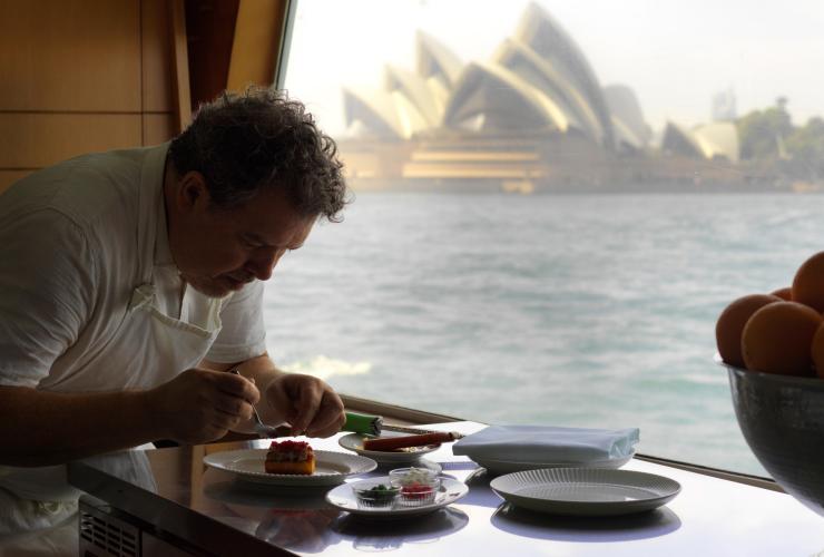 “Solare”号游艇行政总厨 Pablo Tordesillas Garcia 在备制菜肴，背景中是悉尼歌剧院 © Jason Loucas 版权所有