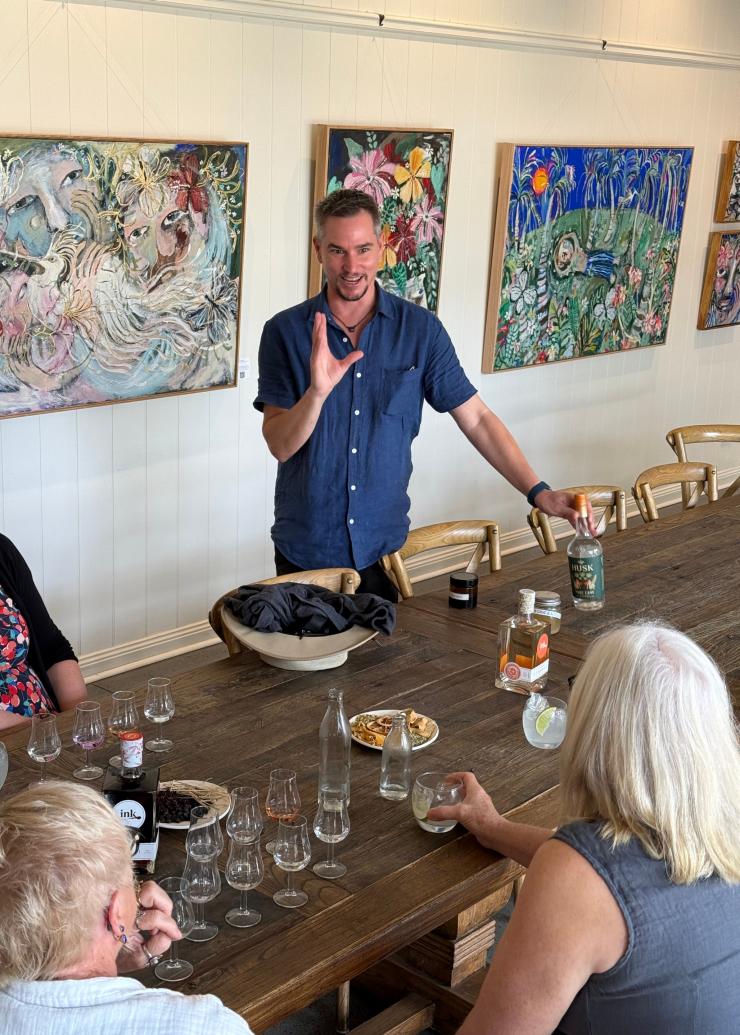 Husk 酿酒师带队的 Ink 杜松子酒体验之旅，游客坐在桌前品尝杜松子酒。© Husk 农场酿酒厂版权所有