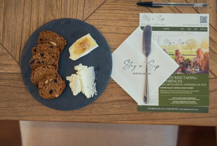 为宾客布置的餐桌，桌上摆放着葡萄酒杯、水杯和品尝拼盘。© Stay n’ Sip 版权所有