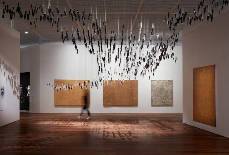 伊里巴娜画廊展览景象，展出作品（从左到右）分别是 Yukultji Napangati 的《无题》（2005 年）、Doreen Reid Nakamarra 的《无题》（2007 年）、Bobby West Tjupurrula 的《Tingari sites around Kiwirrkura》（2015 年）、Ronnie Tjampitjinpa 的《Tingari fire dreaming at Wilkinkarra》（2008 年），以及（上方）Yhonnie Scarce 的《Death zephyr》（2017 年）© Ken Leanfore 版权所有