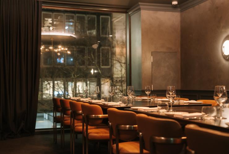 设有已摆放好餐具的餐桌和落地窗的私人餐厅。© Arianna Leggiero 版权所有