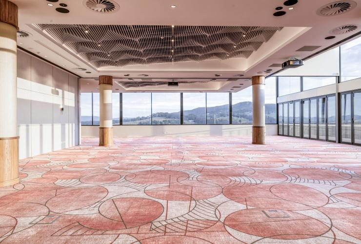 配有落地窗和珊瑚色调瓷砖地面的揽景厅。© 山景庄园版权所有